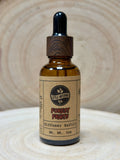 Bottle of 'Forest Fruits' diffuser refill with wooden dropper on a textured surface