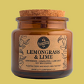 An amber glass jar candle with a natural cork lid and a tan paper label reading 'LEMONGRASS & LIME' by Little Inferno, photographed against a plain light gray background.