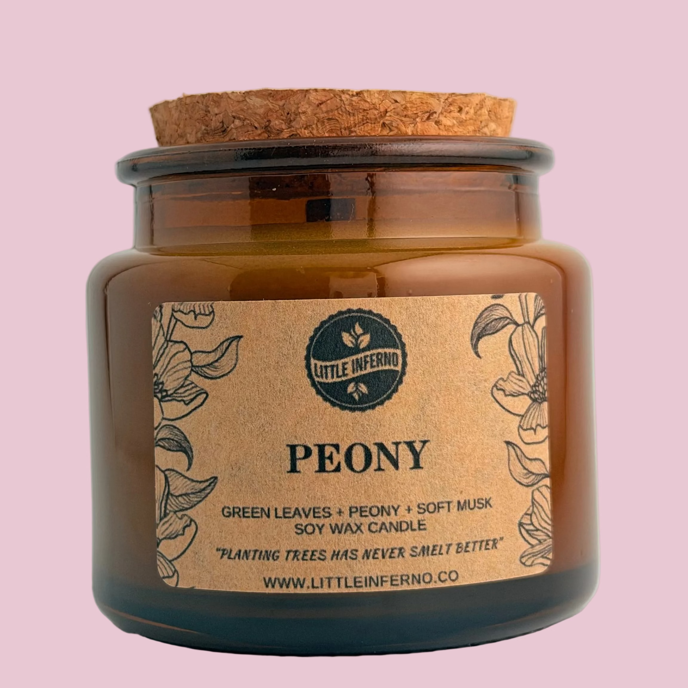 An amber glass jar candle with a cork stopper and a kraft paper label reading 'Little Inferno' and 'Peony' on a light gray background.