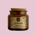 Brown candle jar with cork lid and 'Lavender' label on a pink background