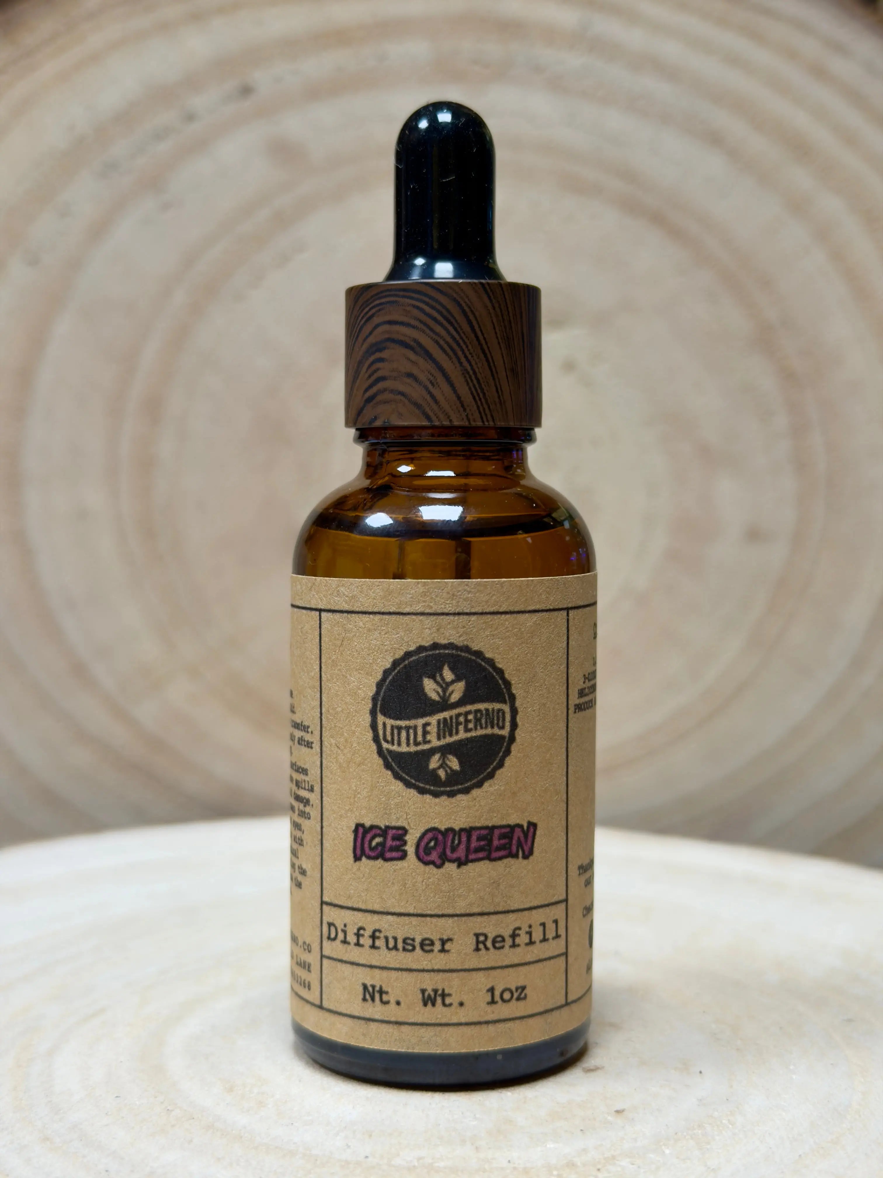 Brown glass bottle with wooden dropper labeled 'Ice Queen' on a beige background