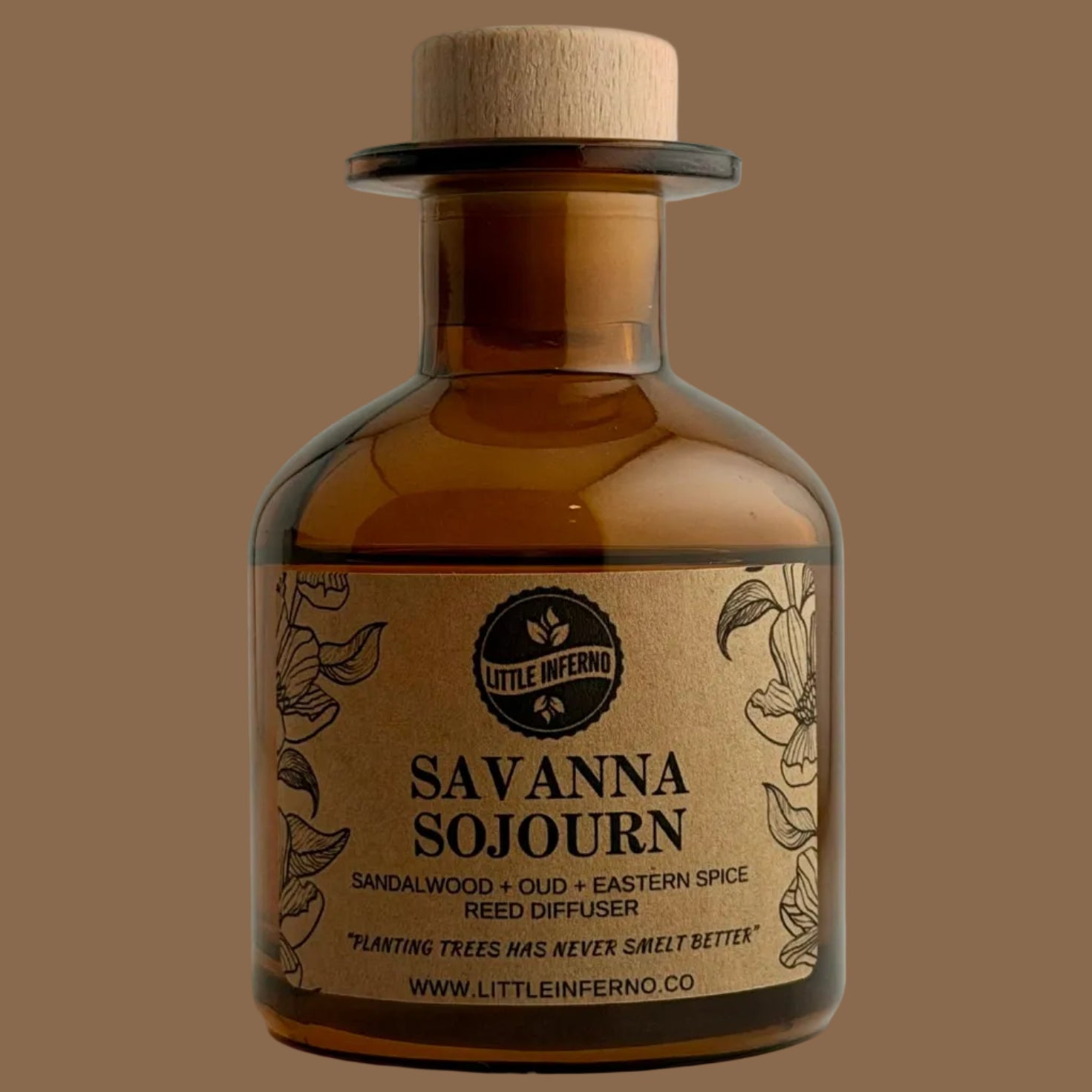 A small amber glass bottle with a cork stopper and a kraft paper label reading 'Savanna Sojourn' by Little Inferno, photographed against a plain light background.