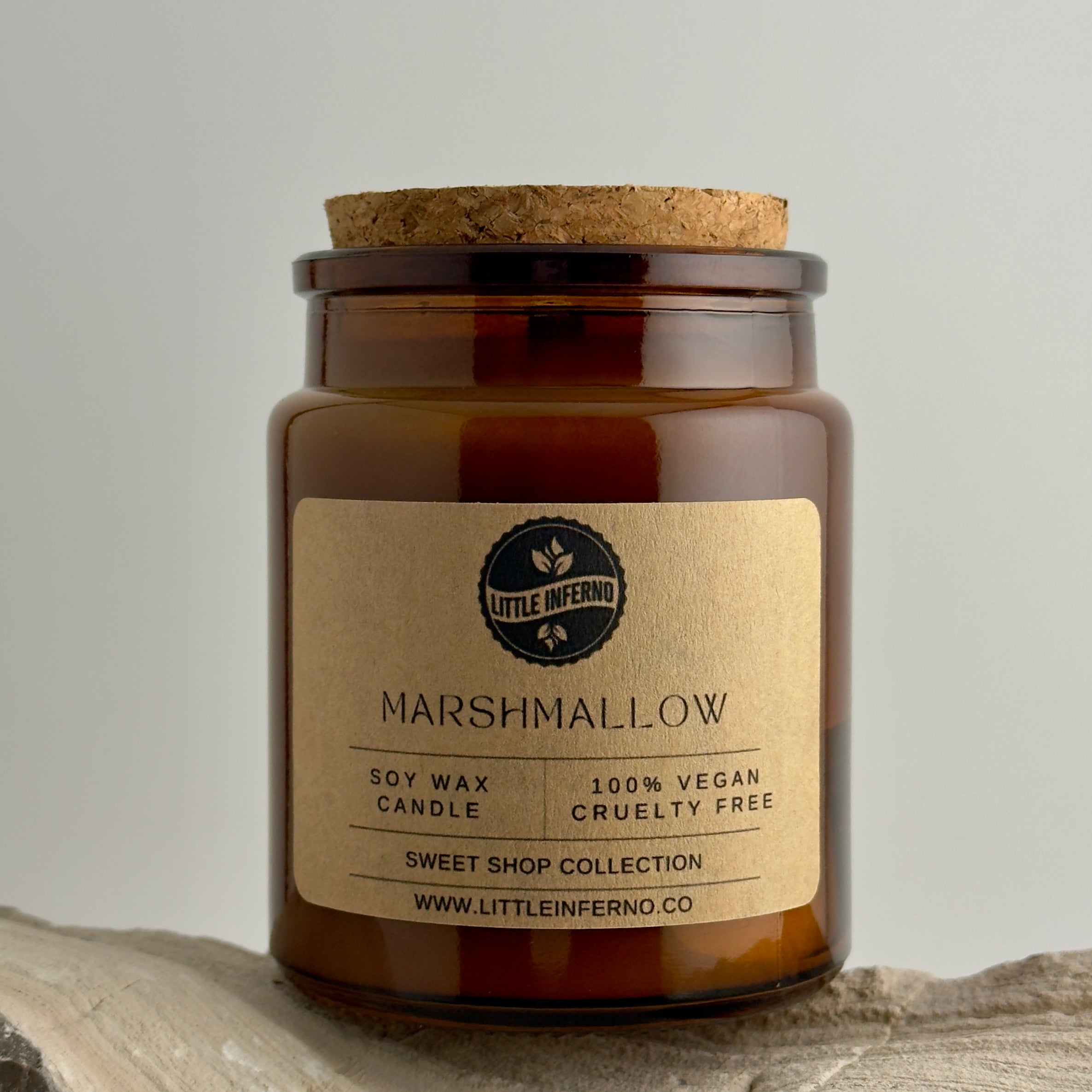 Scented candle in a glass jar with a cork lid on a neutral background