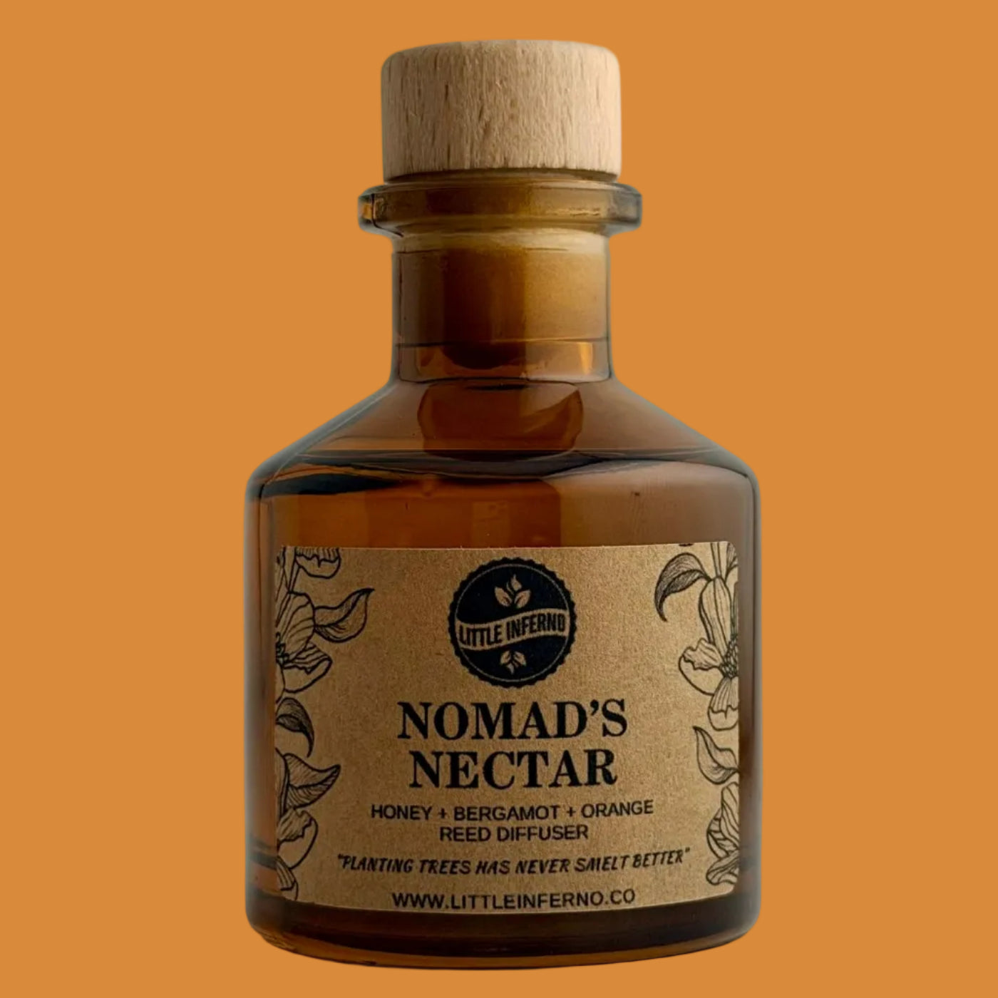 An amber glass bottle of Little Mermaid Nomad's Nectar with a light wood cork stopper and a kraft paper label, set against a plain light gray background.