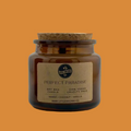 Jar candle labeled 'Perfect Paradise' on an orange background