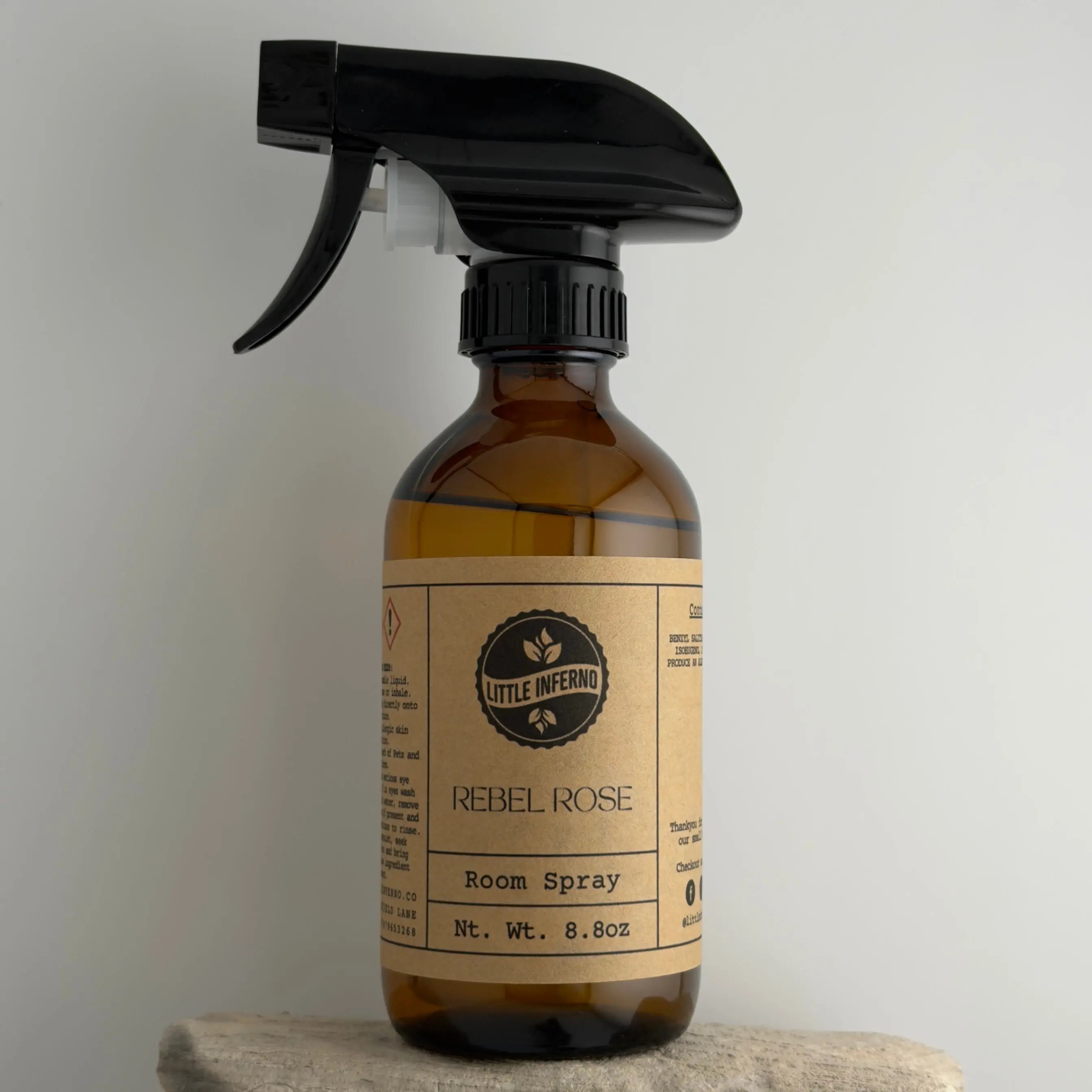 Brown spray bottle with black nozzle on a light gray background