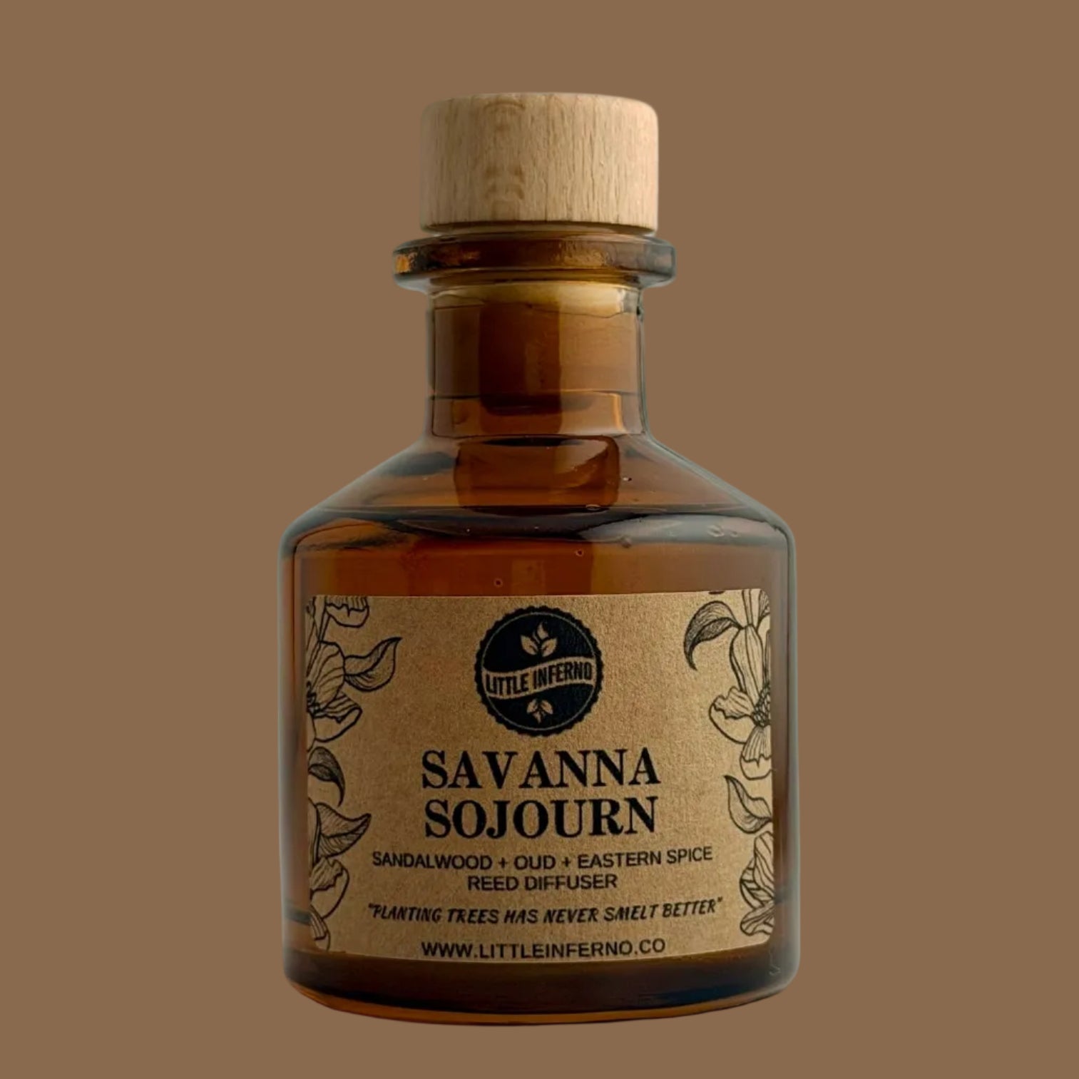 A small amber glass bottle with a light wood cap and a kraft paper label reading 'Savanna Sojourn' by Little Meown, photographed against a plain light gray background.