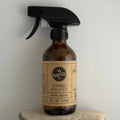 Brown spray bottle with a label on a gray background