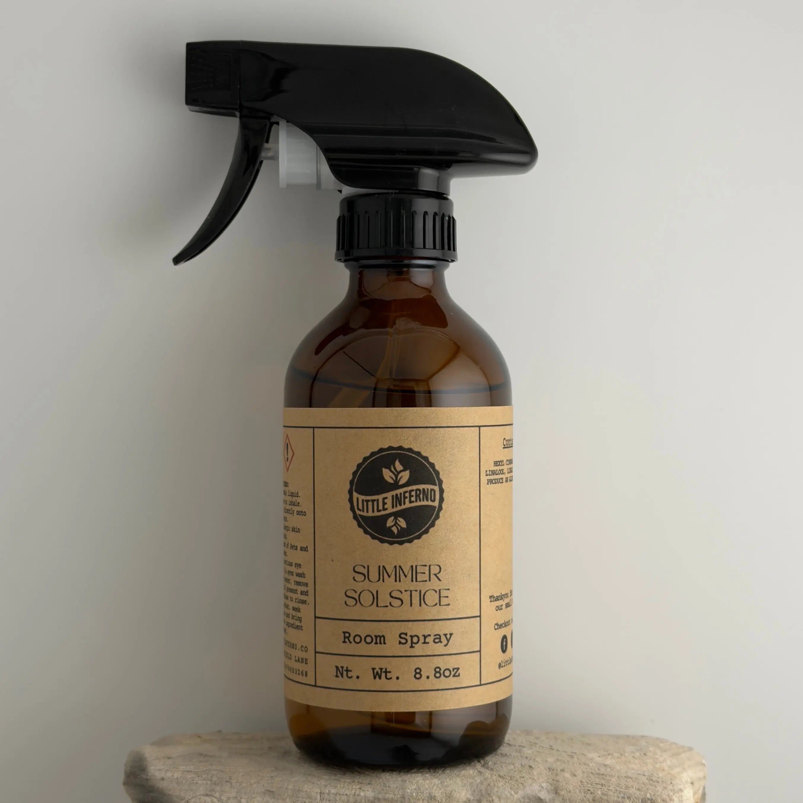 Brown spray bottle with a label on a gray background